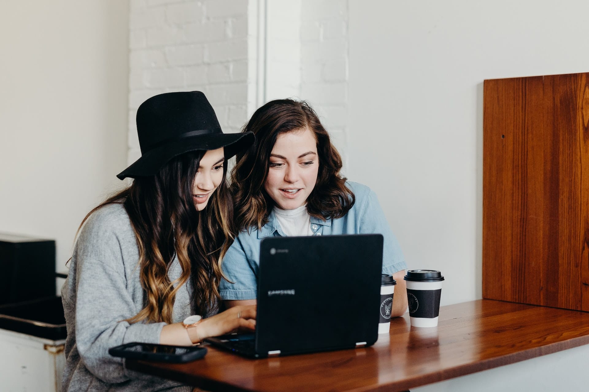 Two young women looking at a laptop screen with great interest