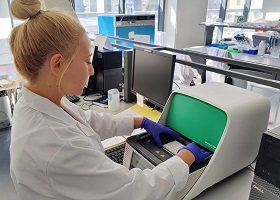 Photo of a female researcher using lab equipment. The image represents the hands-on work at the Essential Molecular Biology – Hands-On Laboratory Course, 25th edition